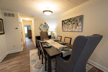 A dining room with a table set for four.
